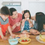 Mother and father encourage their children to try new foods