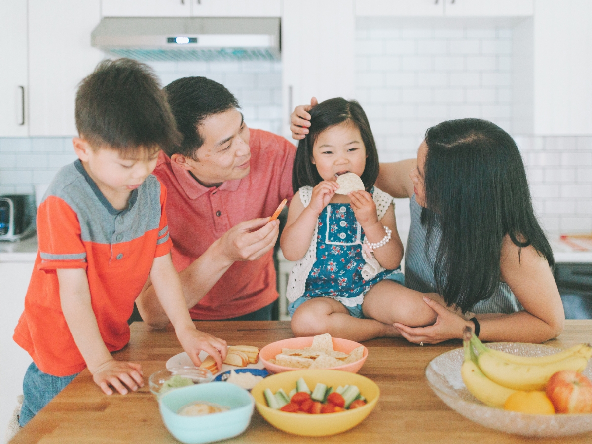 Mother and father encourage their children to try new foods